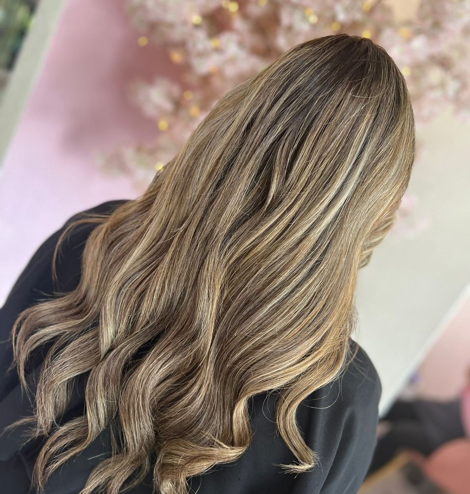 Client with long balayage at Stilo Salón, Roma Norte, with the salon behind her